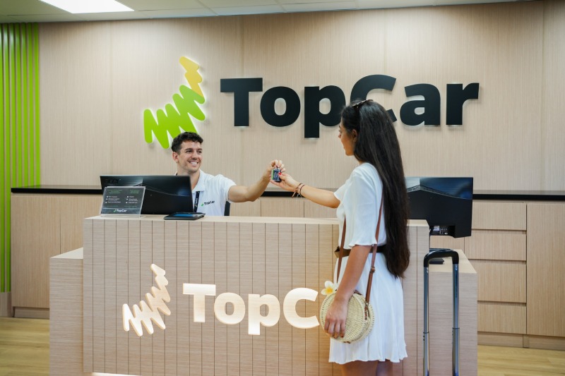 A holidaymaker collecting the keys to their hire car at the TopCar desk.